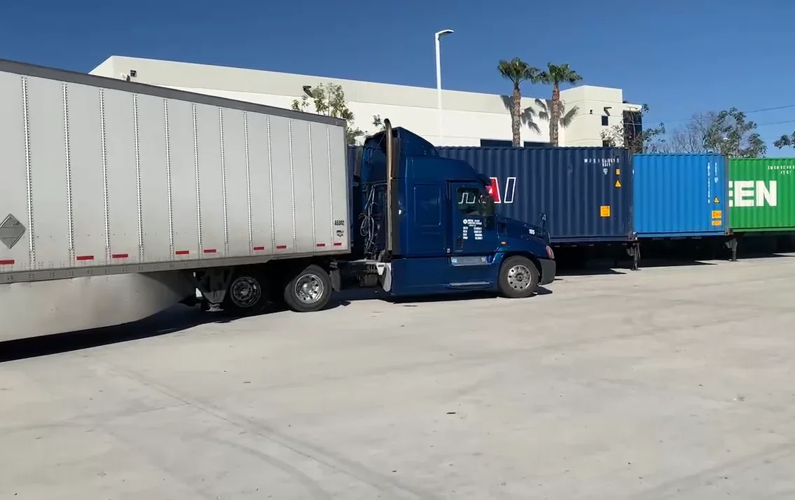 Shipping container being transferred at a freight terminal