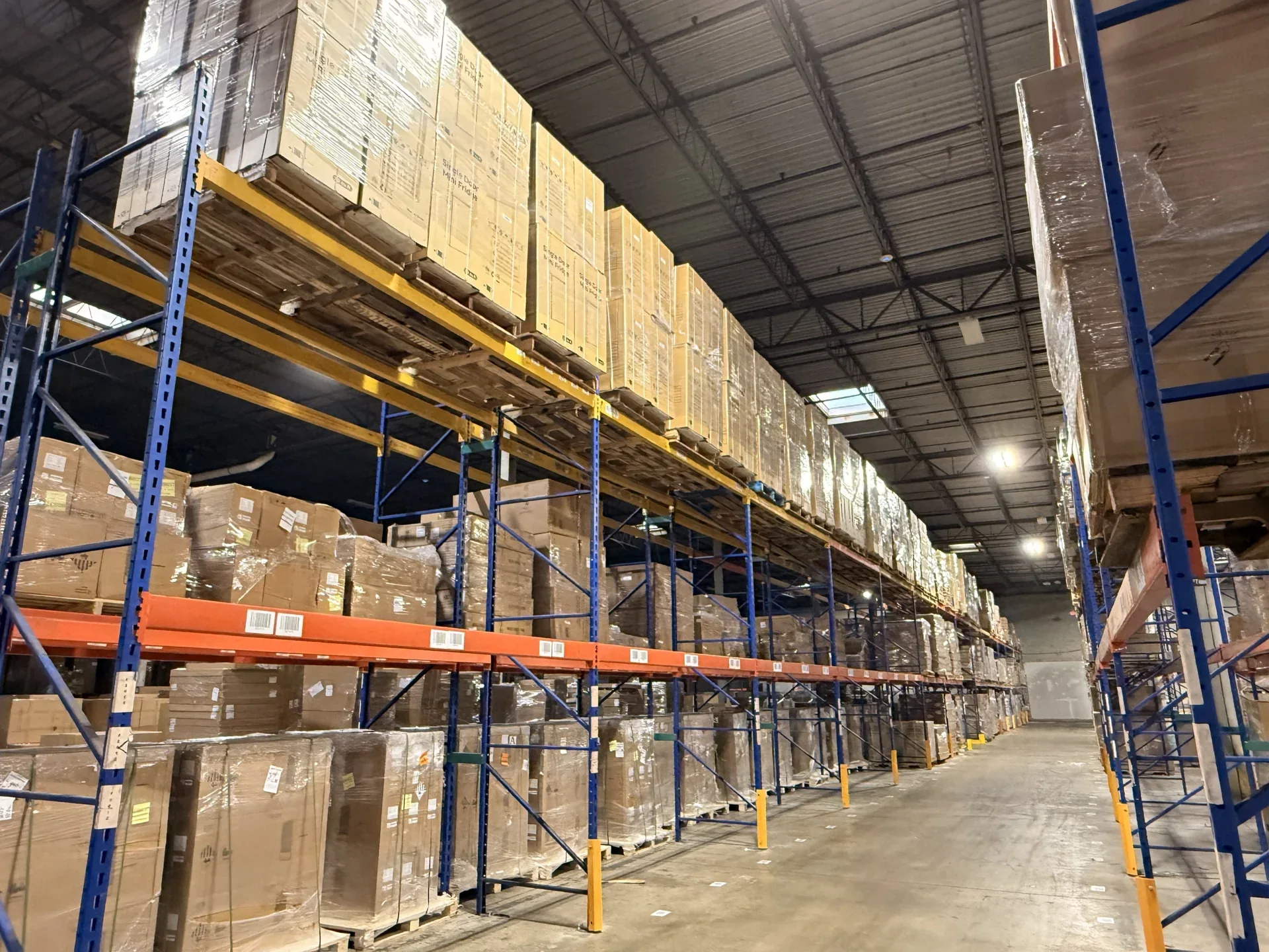 Warehouse aisle lined with pallet racks and stored cargo
